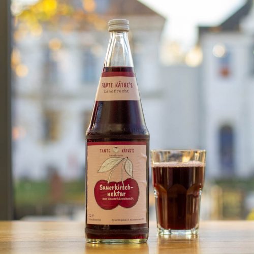 getränke nordmann eigenmarken tanthe käthe kirsche eine flasche und ein glas von tanthe käthe auf einem tisch